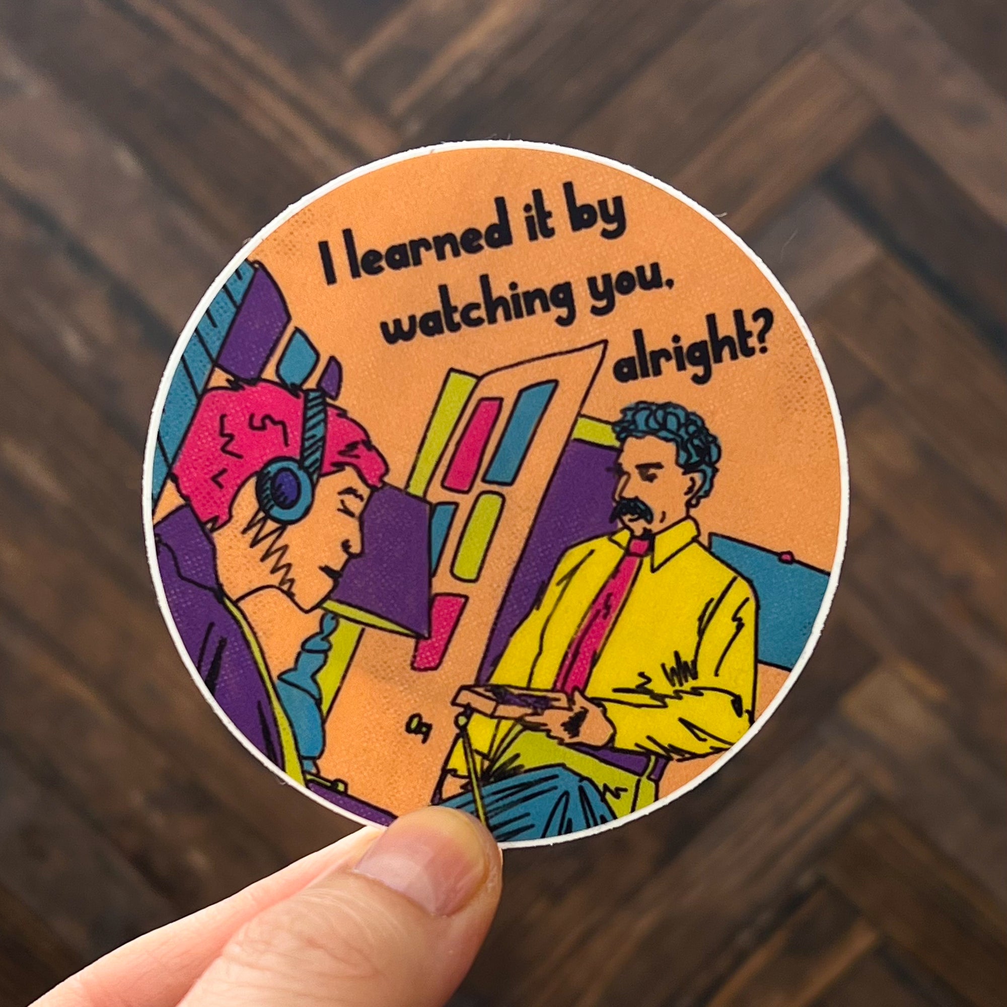 A round sticker with an illustration of the "I learned it by watching you, alright? commercial