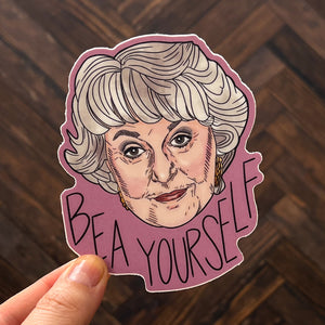 An illustrated sticker of legendary actress Bea Arthur set against a wooden background